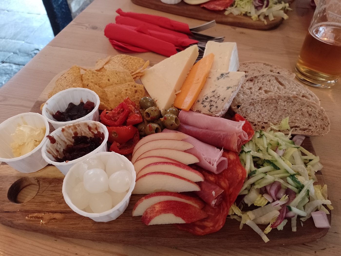 A ploughmans board with ham, cheese, bread and pickles